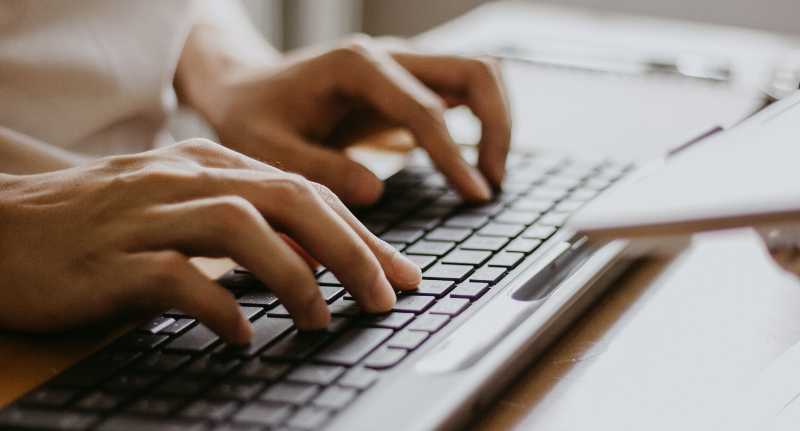 pessoa digitando no teclado do computador para emitir cartão CNPJ